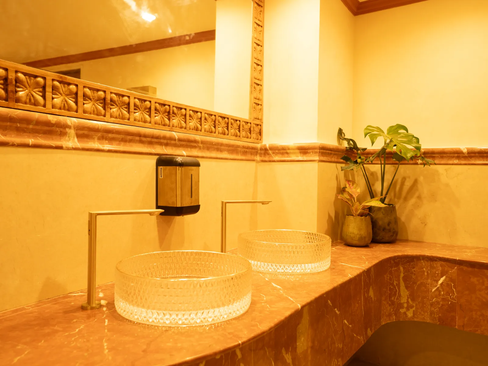 Washroom with curved marble counter and glass basins — Chalukya Samrat